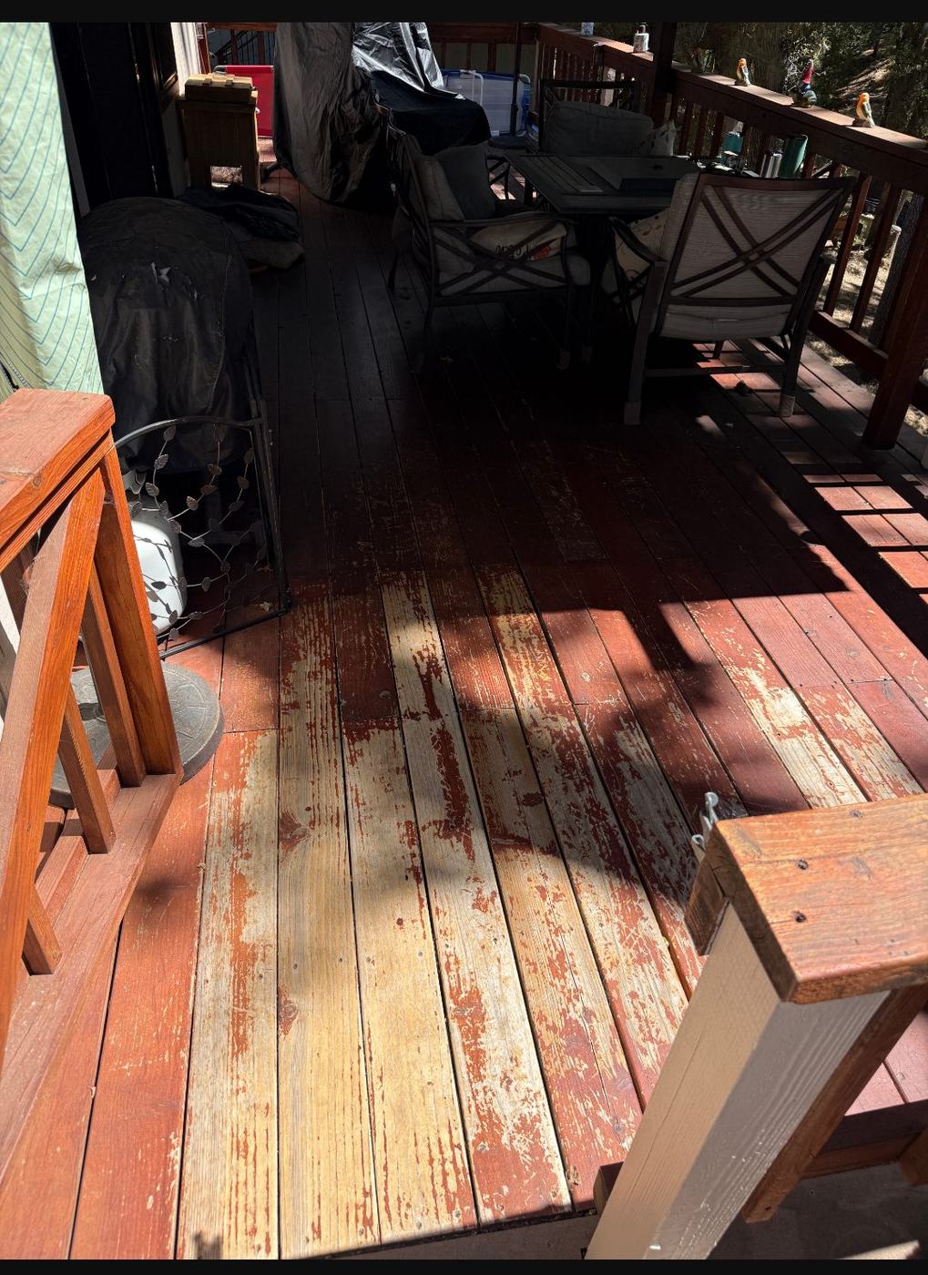 Close view of a deck with stain peeling away from bare timber