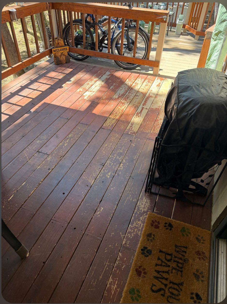 A worn deck with the old stain flaking off the boards